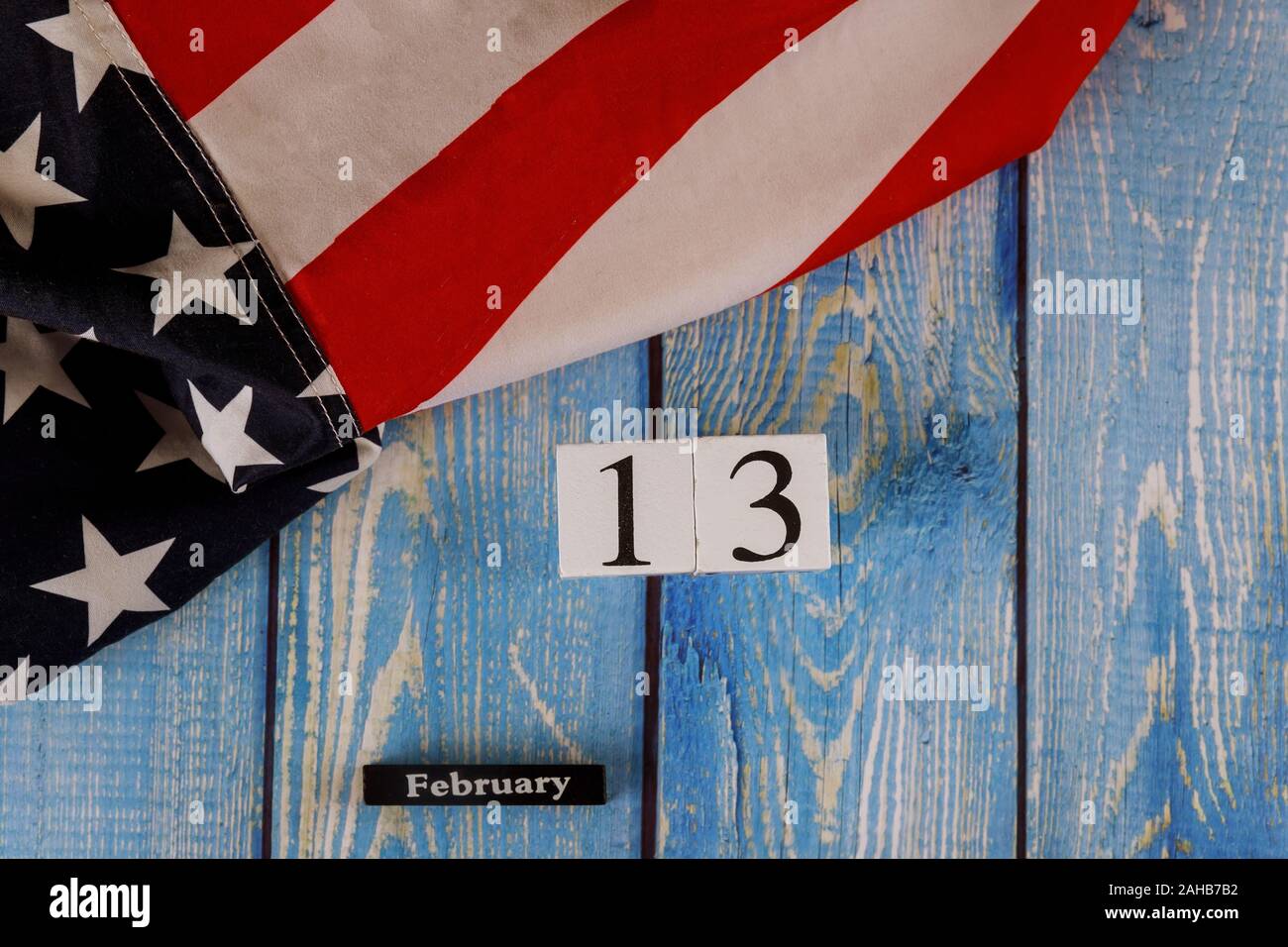 13. Februar Kalender schön Sterne winken und gestreifte amerikanische Flagge auf alten Blau Holzbrett. Stockfoto