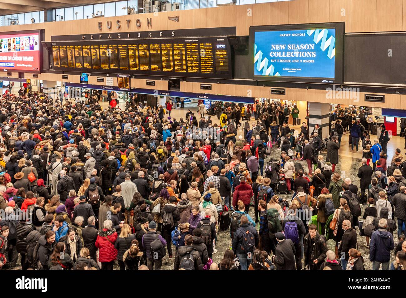 Sehr große Massen in London Euston Hauptbahnhof Halle mit Blick auf die abfahrtstafeln. London, England. Stockfoto