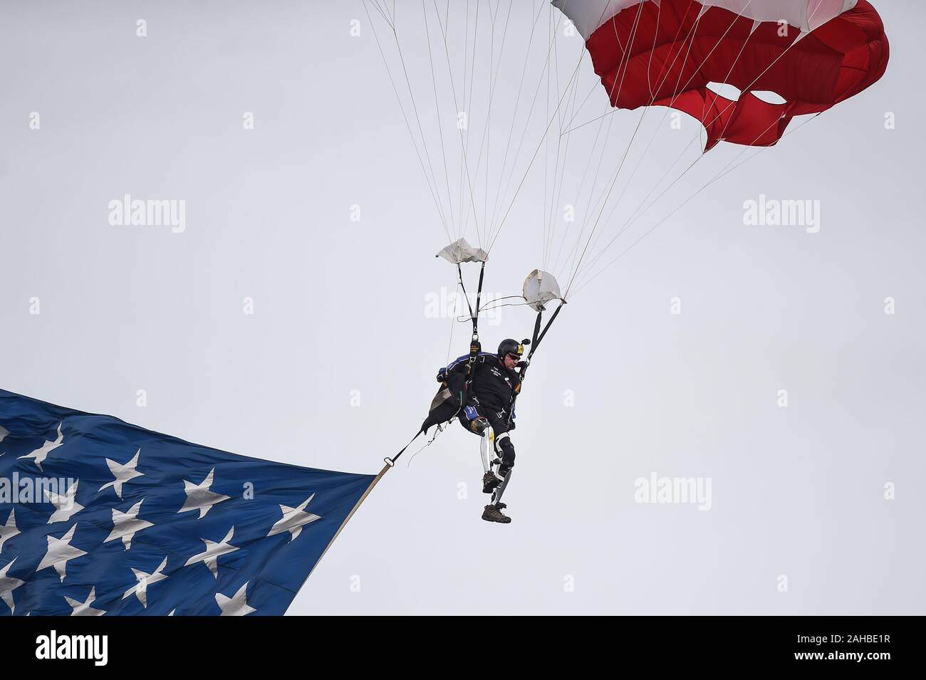 Dez 27, 2019: Landung mit der amerikanischen Flagge ist Dana Bowman, ein Veteran der US Army Sergeant First Class, die als Special Forces Soldat und Mitglied der Armee Fallschirm Team serviert, die goldenen Ritter. Bowman ist ein doppeltes amputee, der seine Beine in einem Mitte verloren - eine Kollision während der goldene Ritter Training. Ge flog vor das matchup zwischen UNC Tar Heels und den Tempel Eulen am militärischen Schüssel am Navy-Marine Corps Memorial Stadium in Annapolis, MD. Stockfoto