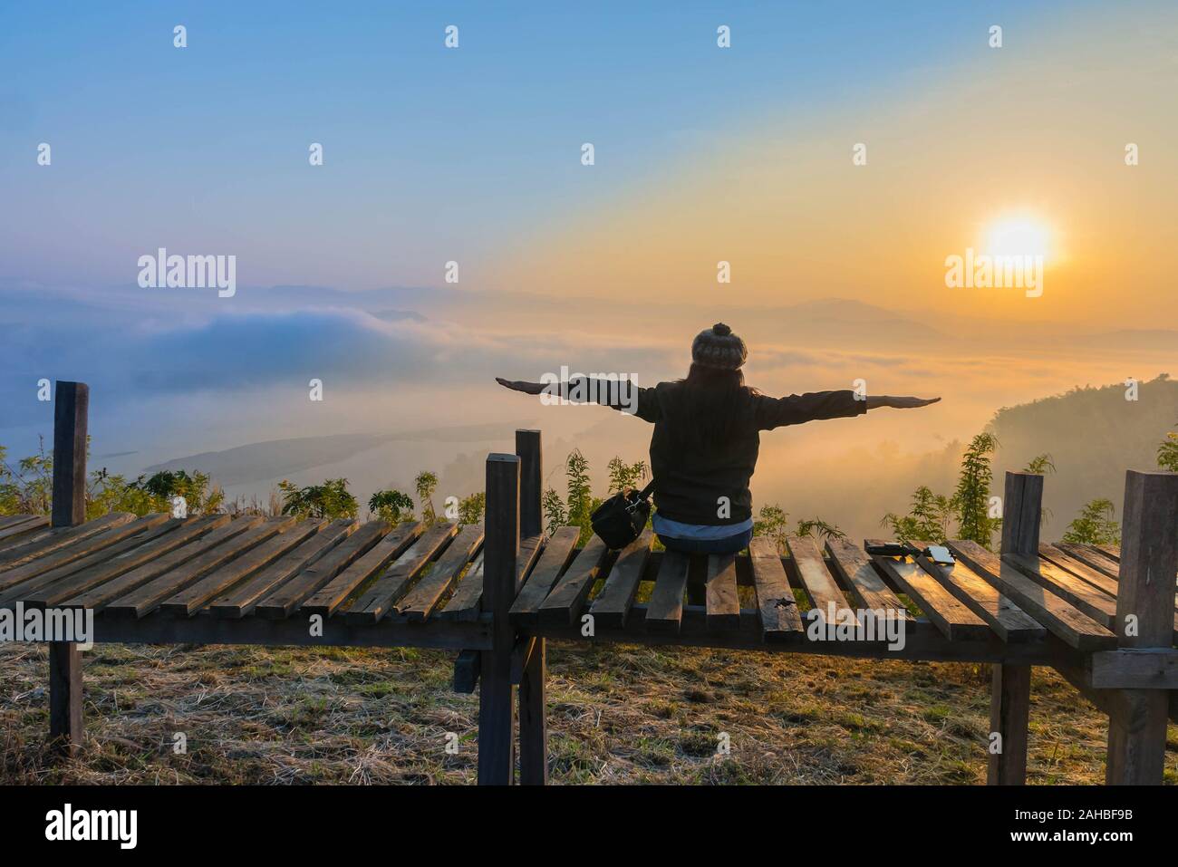 Silhouette den Sonnenaufgang mit einem Holz- Skywalk, der Nebel, die schönen Himmel und Wolken im Phu Lam Duan Berg, Pak Chom Bezirk, Provinz Loei, Thailan Stockfoto