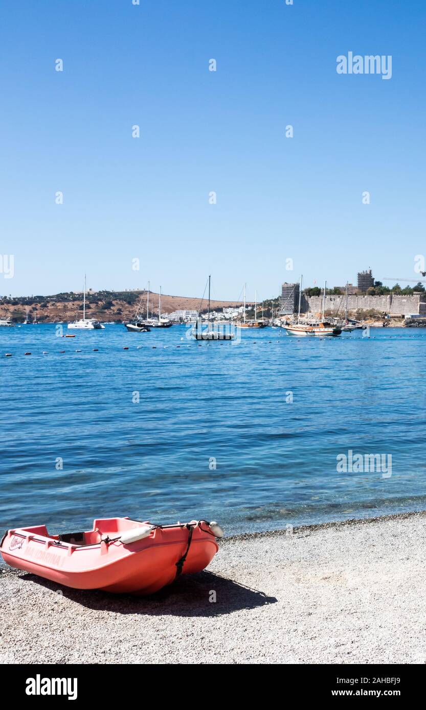 Boot auf steinigen Strand mit im Hintergrund das Schloss, Bodrum, Türkei Stockfoto