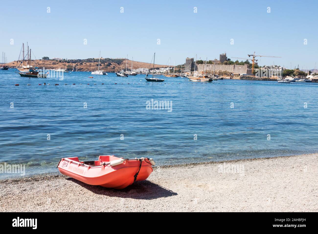 Boot auf steinigen Strand mit im Hintergrund das Schloss, Bodrum, Türkei Stockfoto