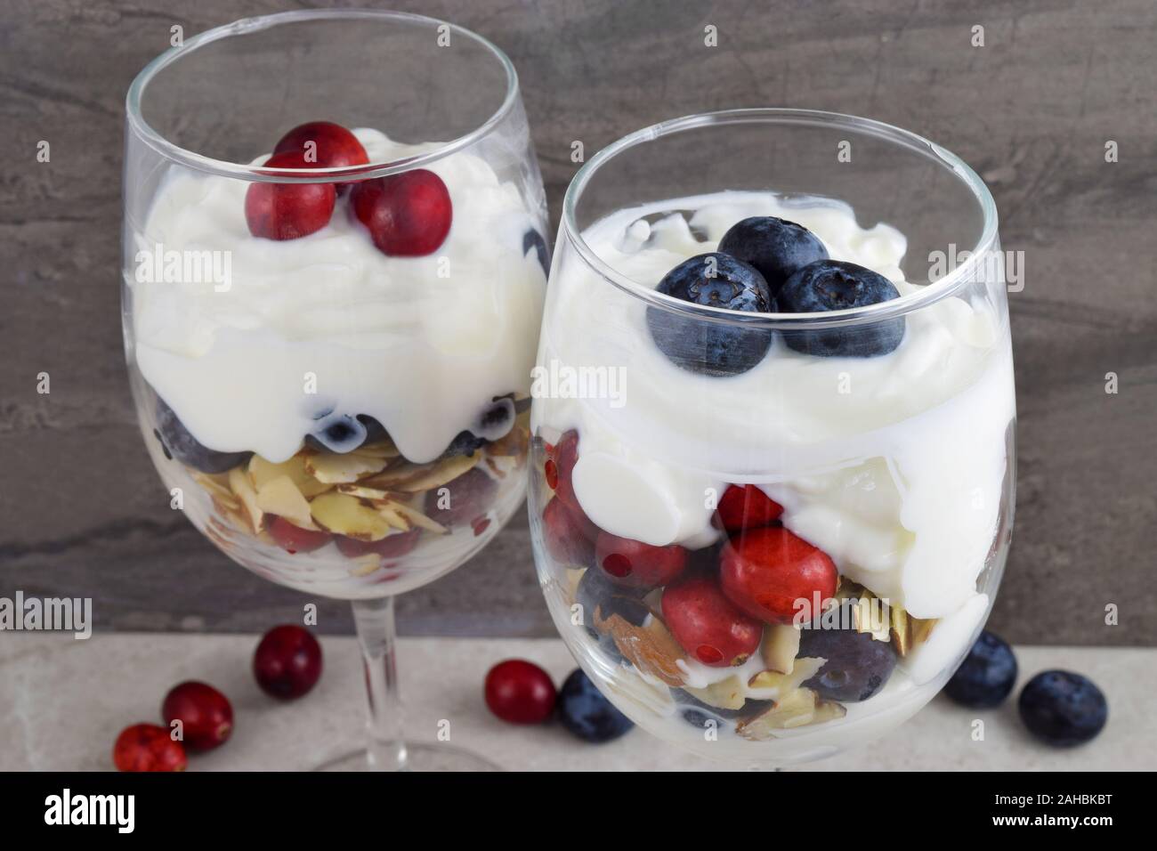 Wineglass parfaits mit frischen roten Cranberries mit frischen Blaubeeren, Joghurt und gehobelten Mandeln geschichtet. Ein leckeres patriotischen Dessert. Stockfoto