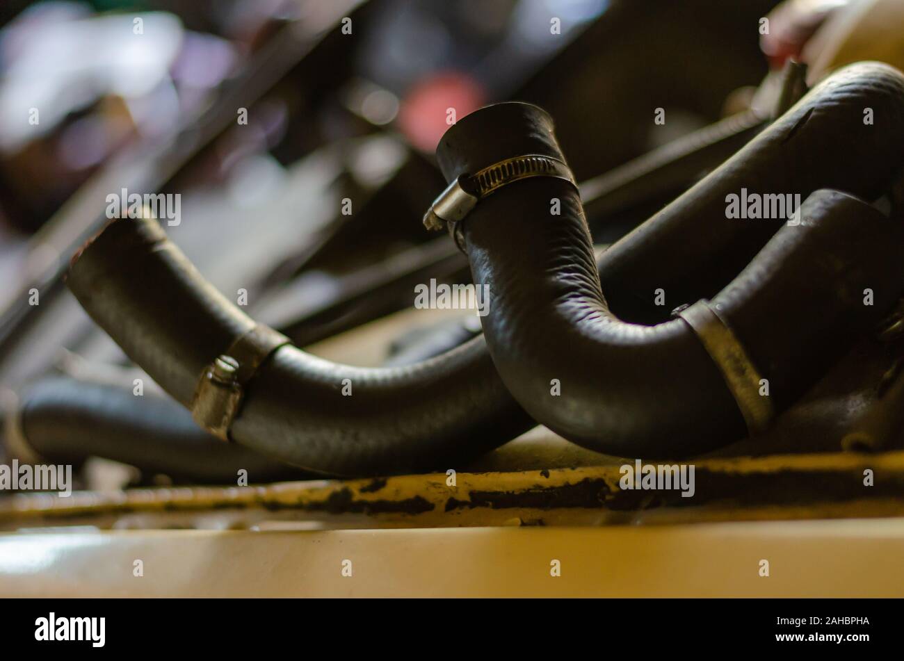 Gummischläuche einer Kühlung für einen Pkw mit Metall klemmen. Ein Dokumentarfilm gedreht in einer alten Werkstatt. Augenhöhe schießen. Close-up. Stockfoto
