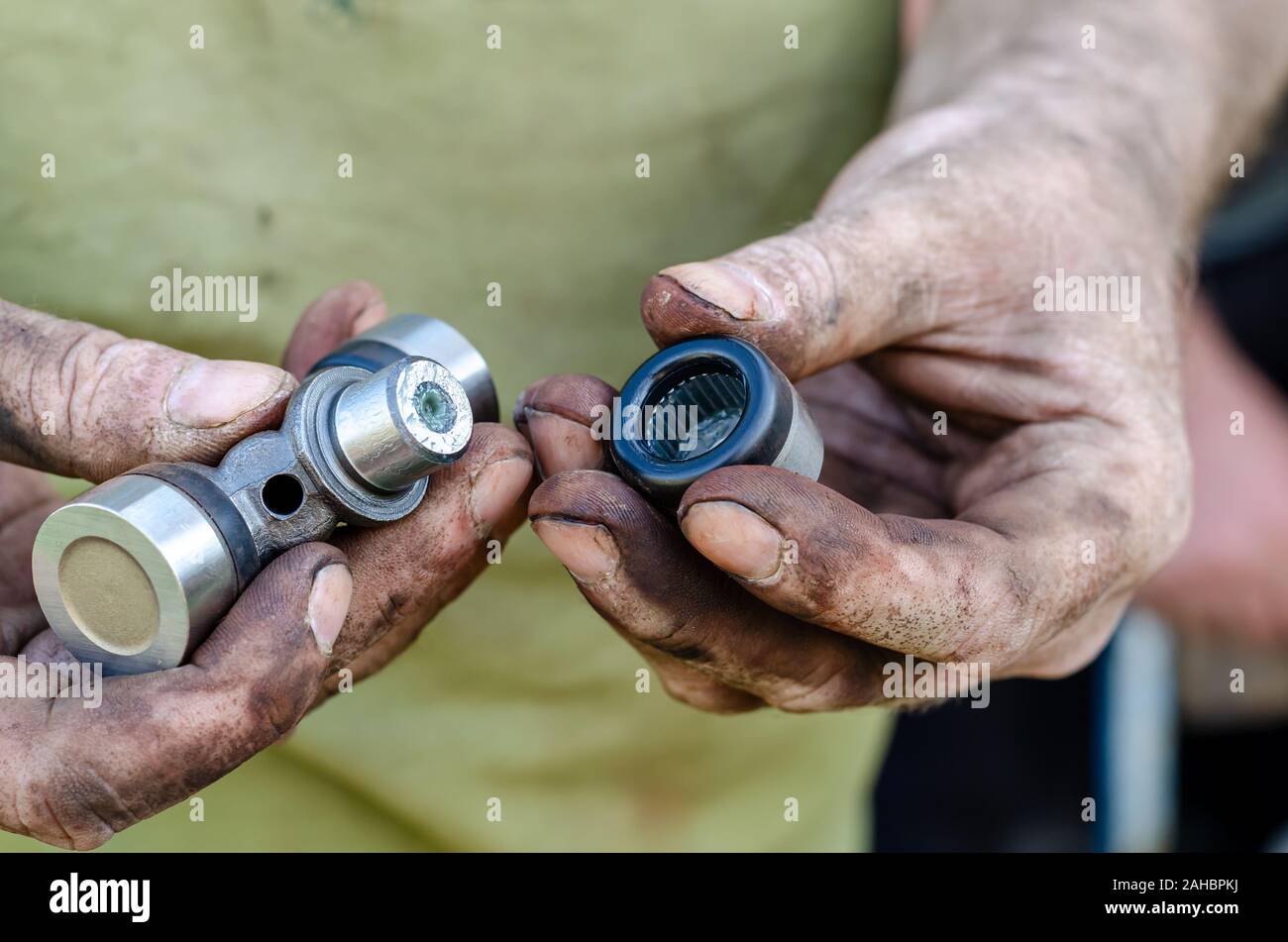 Der automechaniker inspiziert und schmiert die neue Nadel Lager der Kardanwelle vor der Installation auf dem Auto. Augenhöhe schießen. Stockfoto