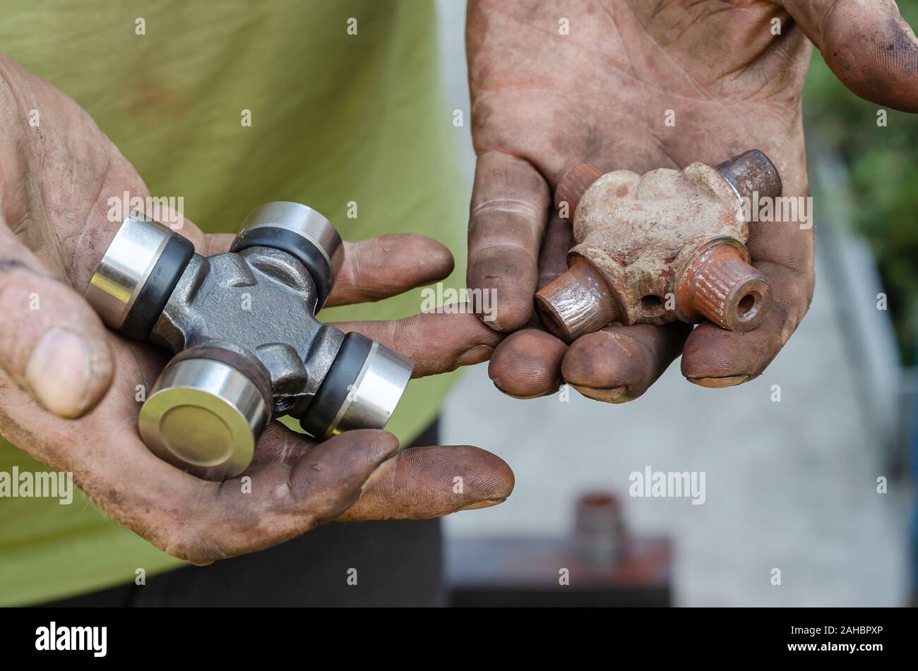 Abgenutzt und neue Teile für Autos in schmutzigen männlichen Händen. Augenhöhe schießen. Soft Focus. Close-up. Stockfoto