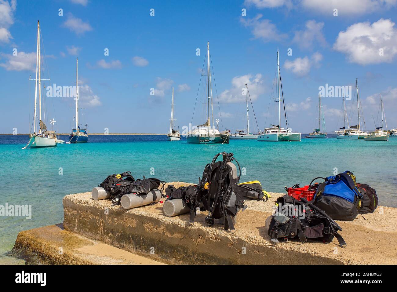 Tauchausrüstung an der Küste von Bonaire mit Segelbooten auf Meer Stockfoto