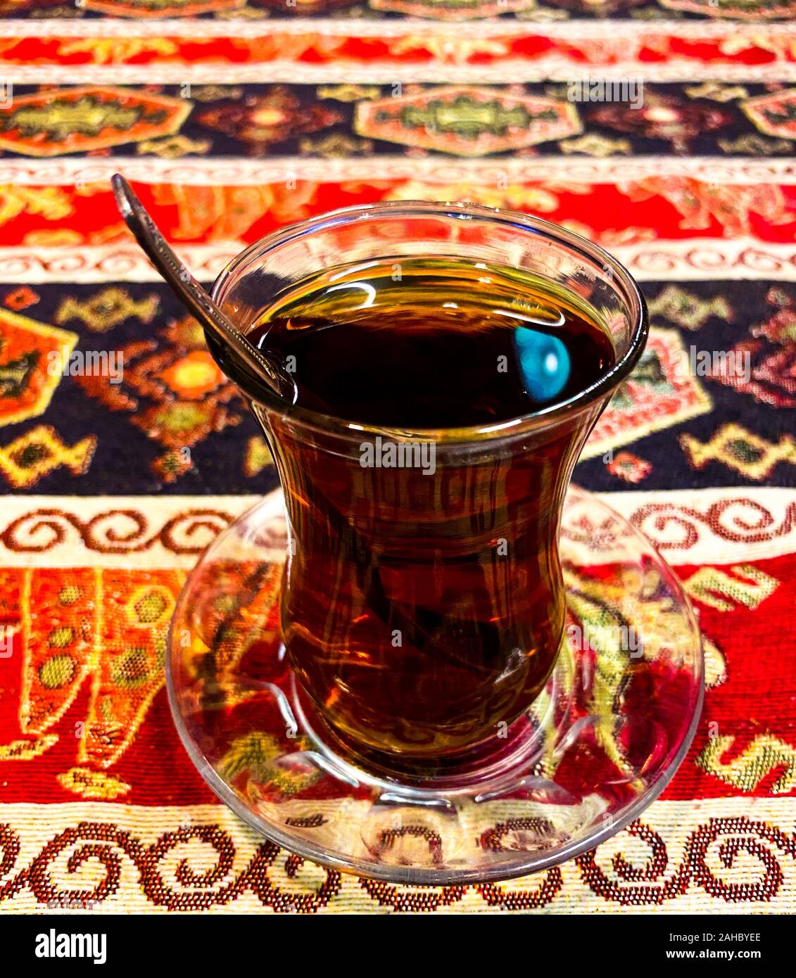 Ein Türkischer Pokal mit schwarzem Tee steht auf dem Tisch vor dem Hintergrund der Türkischen Ornament. Türkische Traditionen. Stockfoto