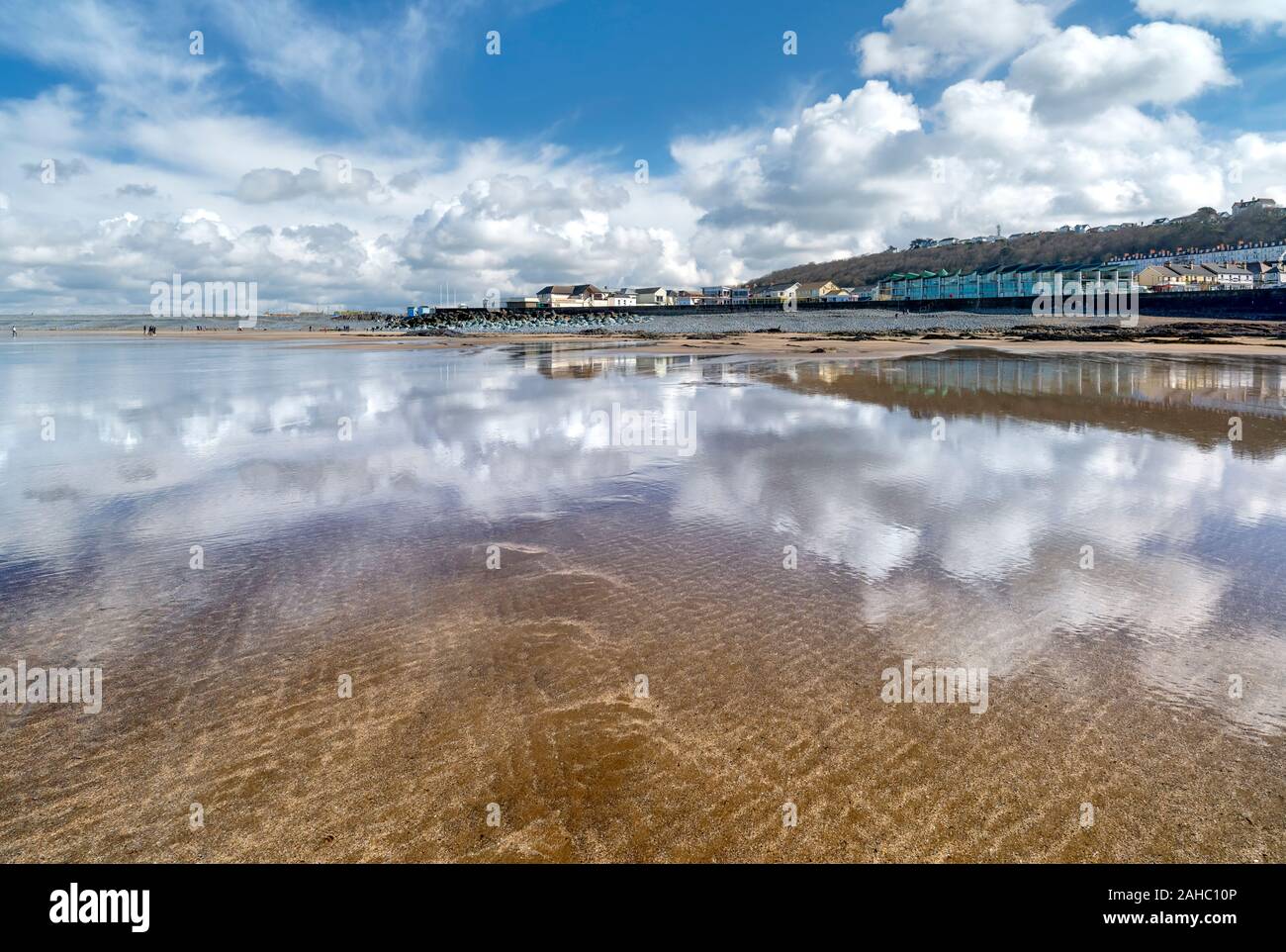 Weiße Wolken reflektieren im feuchten Sand bei Westward Ho! Strand, North Devon, Großbritannien Stockfoto