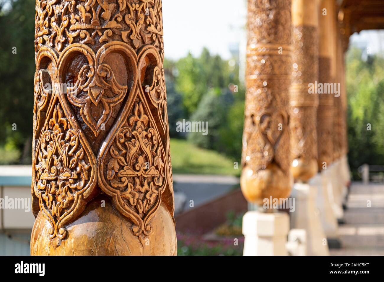 Detail einer kunstvoll geschnitzte hölzerne Säule, mit anderen Säulen im Hintergrund, in Taschkent, Usbekistan. Stockfoto