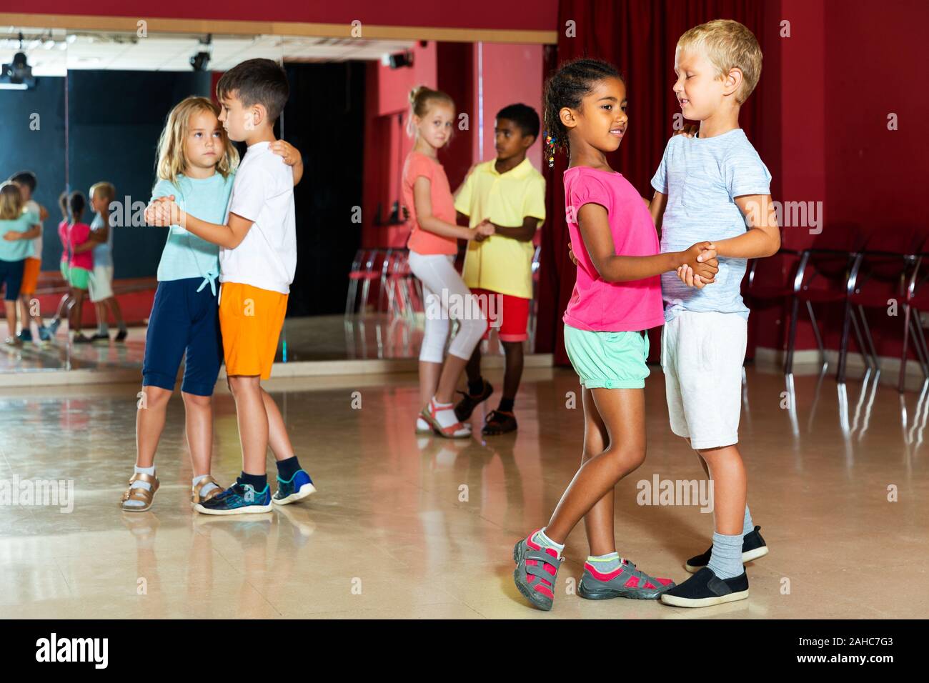 Lächelnde Kinder Grundschule versucht, Tanzen der Partner Tanz in Modern Dance Studio Stockfoto