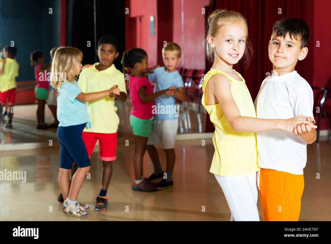 Lächelnde Kinder Grundschule versucht, Tanzen der Partner Tanz im modernen Studio Stockfoto