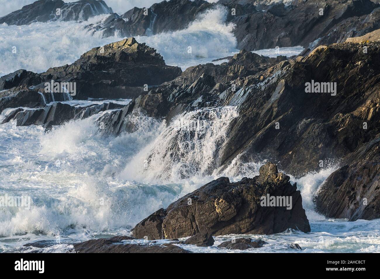 Wellen, die über die Felsen an der Küste von Cornwall. Stockfoto