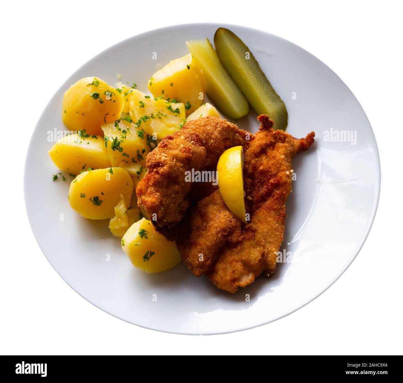 Gericht der Tschechischen Küche - hühnerschnitzel in Parmesan Paniermehl mit gekochten Kartoffeln und Gurken serviert. Auf weissem Hintergrund Stockfoto