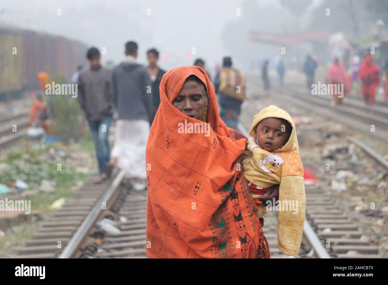 Winter kalt tejgoanischer Bahnhof, 21de2019 tejgoanischer BahnhofDhaka Bangladesh.eine ältere Frau hält das Baby in ihren Armen und wickelt es mit einem Laken um es vor der Kälte zu schützen.Nazmul Islam/alamy Stock Live News Stockfoto
