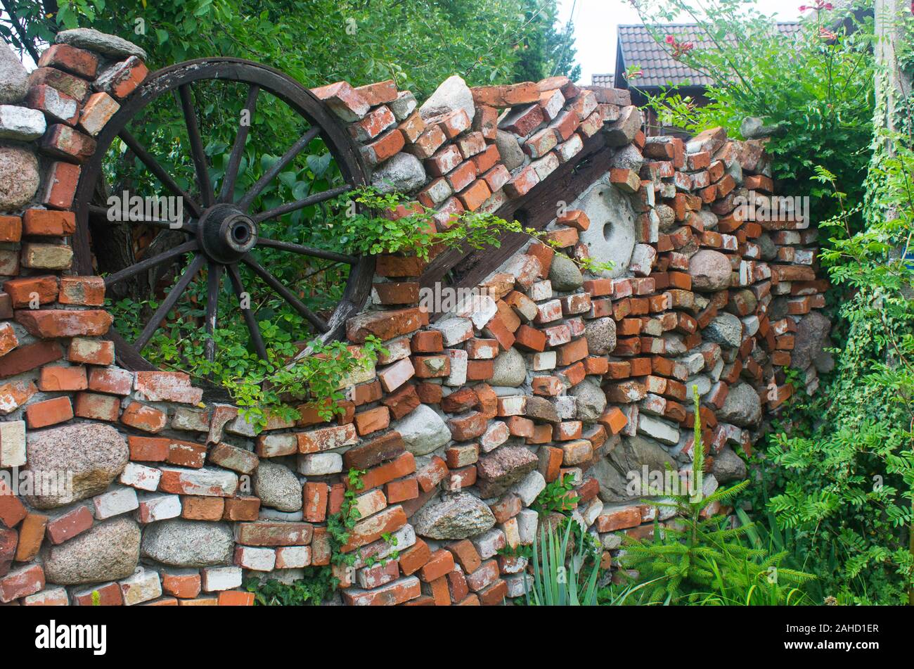 Original brick wall mit einem hölzernen Rad rund um das Privateigentum, Polen Stockfoto