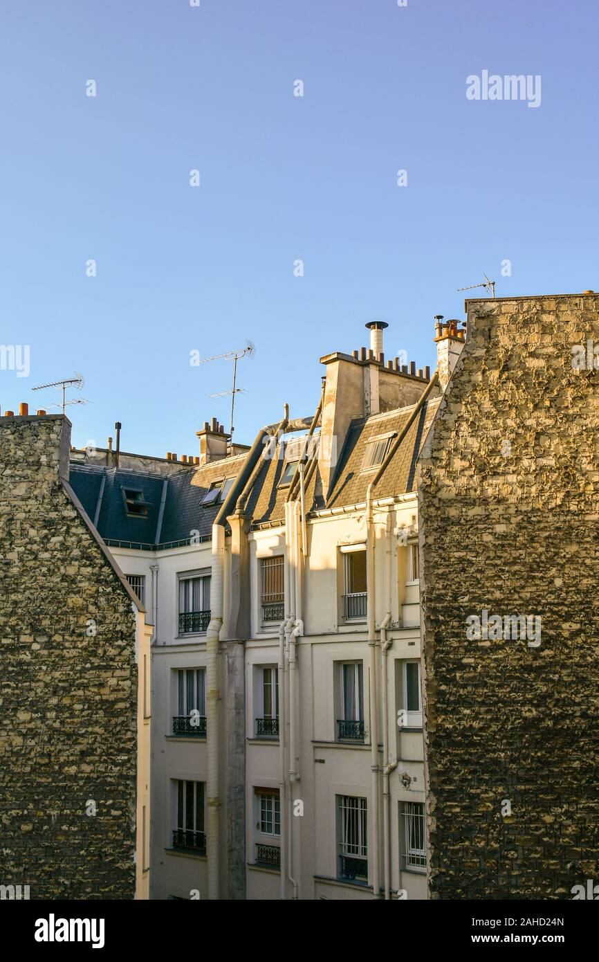 Vertikale Sicht auf die Dächer von einem alten Gebäude im 11. Arrondissement auf der Rive Droite im historischen Zentrum von Paris gegen den blauen Himmel, Frankreich Stockfoto