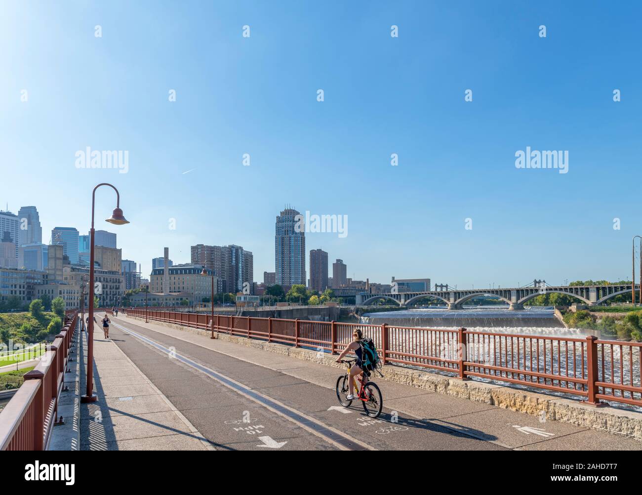 Die Skyline der Innenstadt von der steinernen Bogenbrücke mit St Anthony Falls rechts, Mississippi, Minneapolis, Minnesota, USA Stockfoto