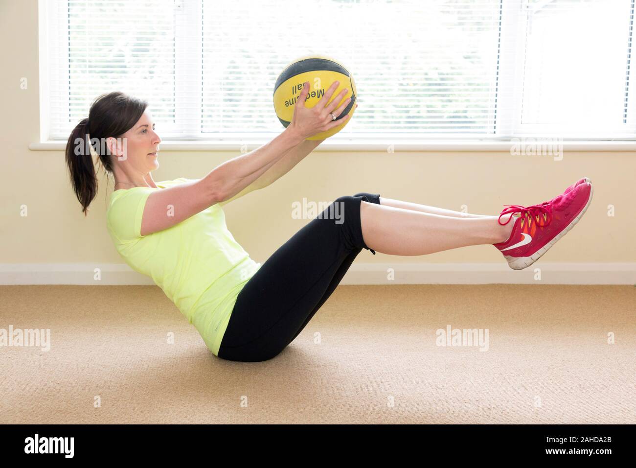 Frau tun sitzen oben Übung mit medizinball Stockfoto