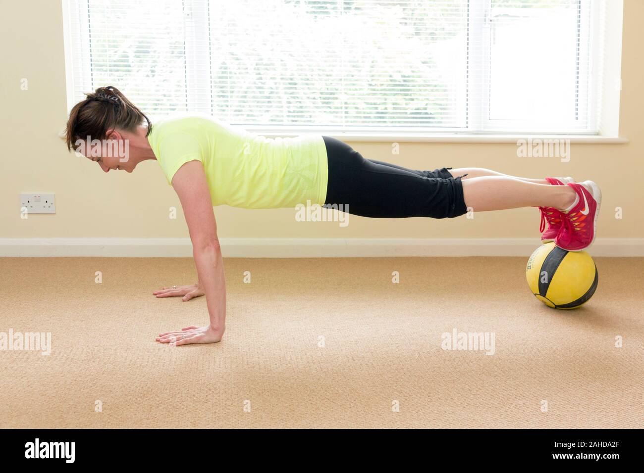 Frau tun Push-ups mit Medizin übung Kugel Stockfoto