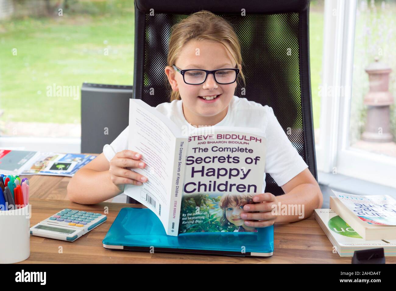 Mädchen lesen Buch über glückliche Kinder Stockfoto