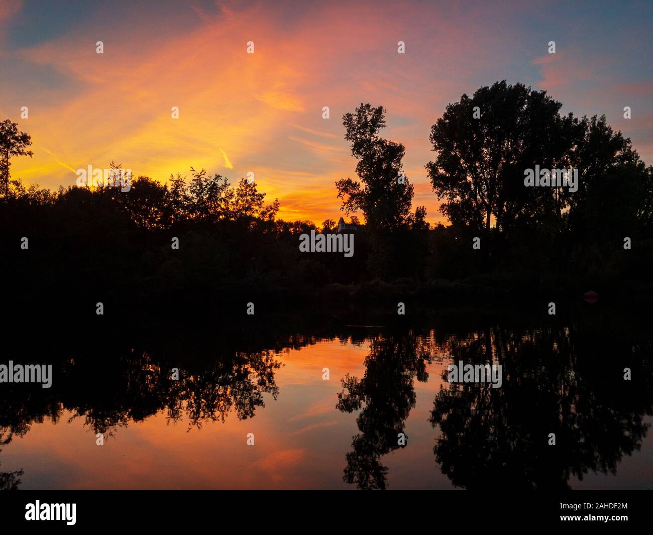 Blick auf das idyllische Tal der Ruhr in Mülheim an der Ruhr, Deutschland mit einem roten Himmel im Wasser spiegeln an einem sommerlichen Abend Stockfoto