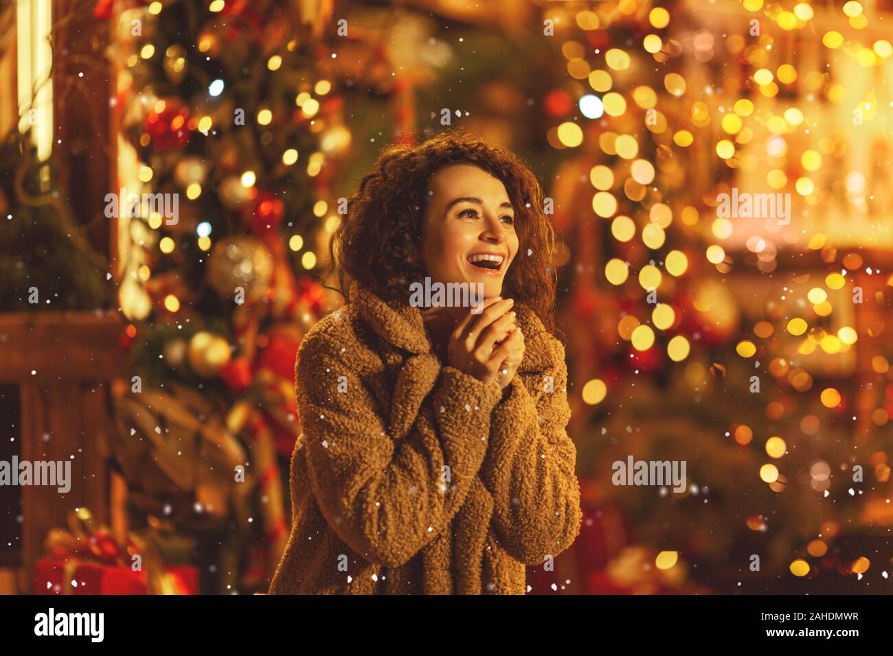 Eine schöne junge Frau genießen eine Tasse Tee oder Kaffee, Glühwein auf dem Weihnachtsmarkt. Stockfoto