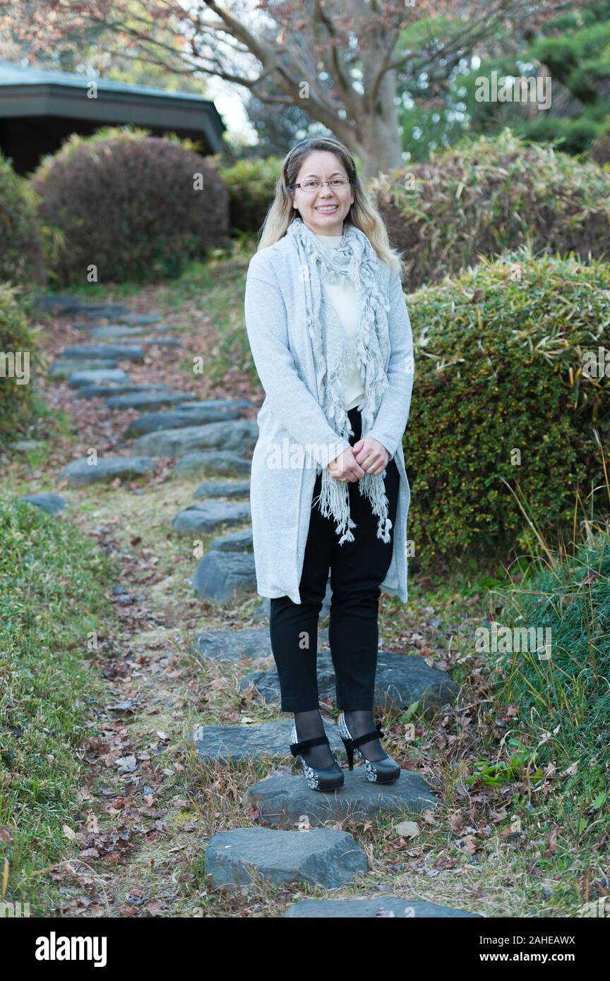 Schönen gemischten Rasse blonde Frau (Brasilien/Japanisch) ständigen Freuen und Lächeln. Vertikale erschossen. Stockfoto