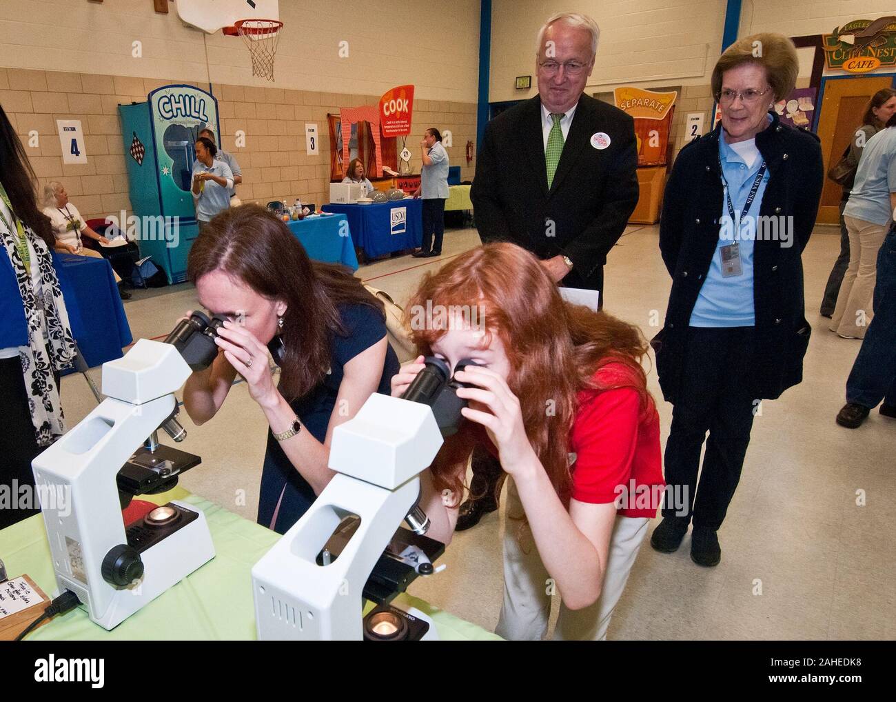 Dr. Elisabeth Hagen (links), Staatssekretärin der Lebensmittelsicherheit und Emily Wise (rechts), eine fünfte Klasse Student an Maryland Stadt Volksschule in Laurel, Maryland Blick durch Mikroskope Listerien und Salmonellen, zwei der vier häufigsten Bakterien in Lebensmitteln gefunden. Die beiden anderen Bakterium Campylobacter und E. coli. Hinter Hagen und Weisen sind Dr. Kevin Concannon, Staatssekretär Verbraucher und Ernährung Dienstleistungen und Barbara Robinson, Food Safety Inspection Service. Die FSIS hielt eine Lebensmittelsicherheit Ausbildung Lager bei Maryland Stadt Volksschule, Do., 5. Mai 2011 Stockfoto