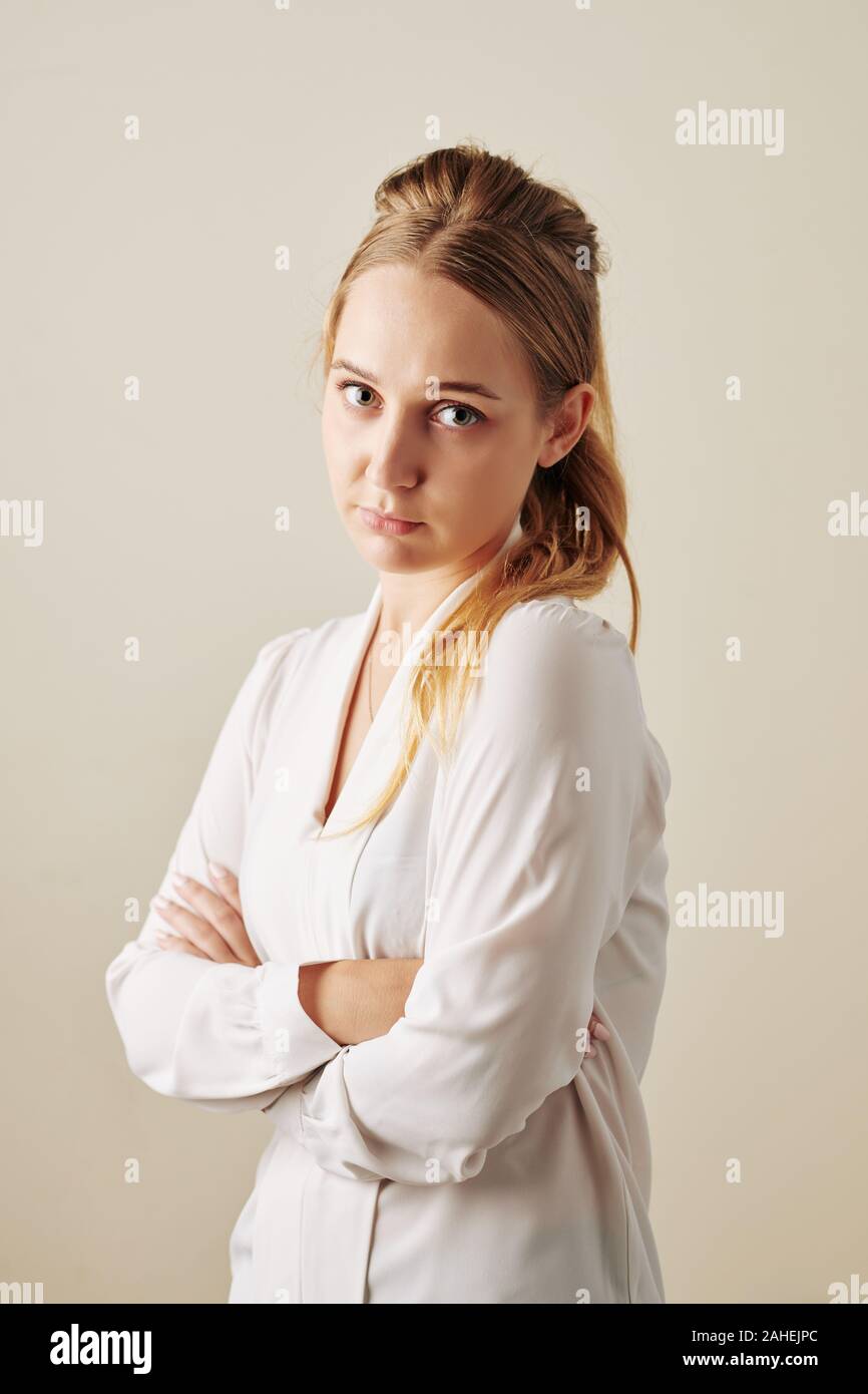 Studio Portrait von beleidigt junge Frau falten Arme und Kamera Stockfoto