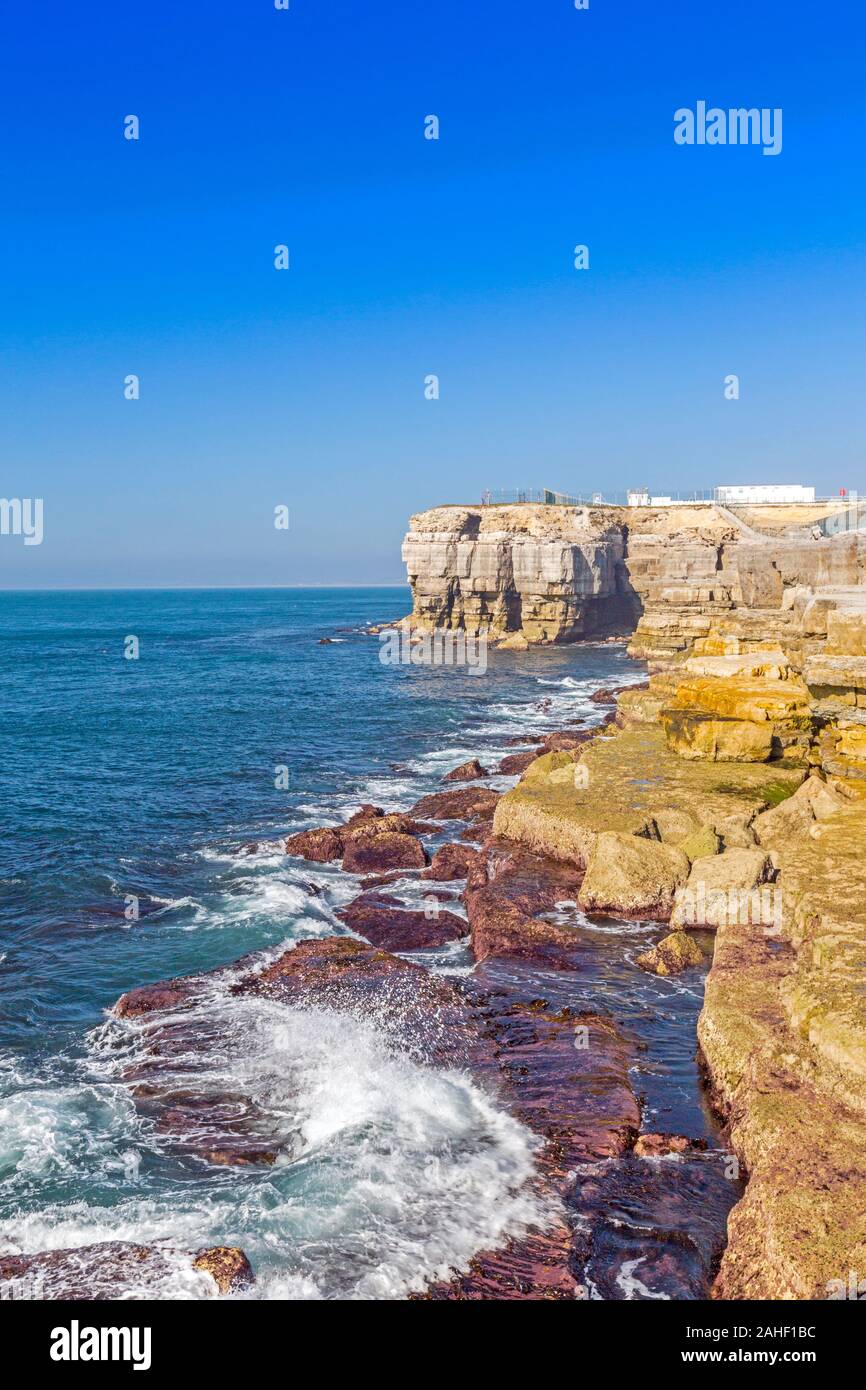 Wellen über die Portland Stein leisten bei niedrigem Wasserstand an der Portland Bill, Dorset, England, Großbritannien, Stockfoto