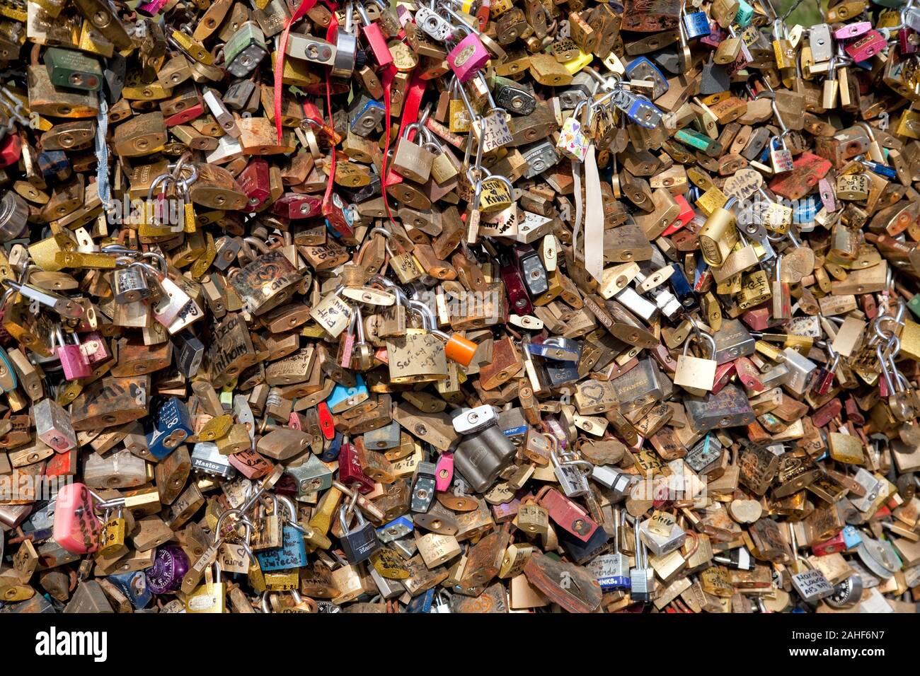 Vorhängeschlösser, die an einem Metallpfench an einer Brücke befestigt sind, zeigen Botschaften der immerwährenden Liebe und des Engagements, Paris France Stockfoto