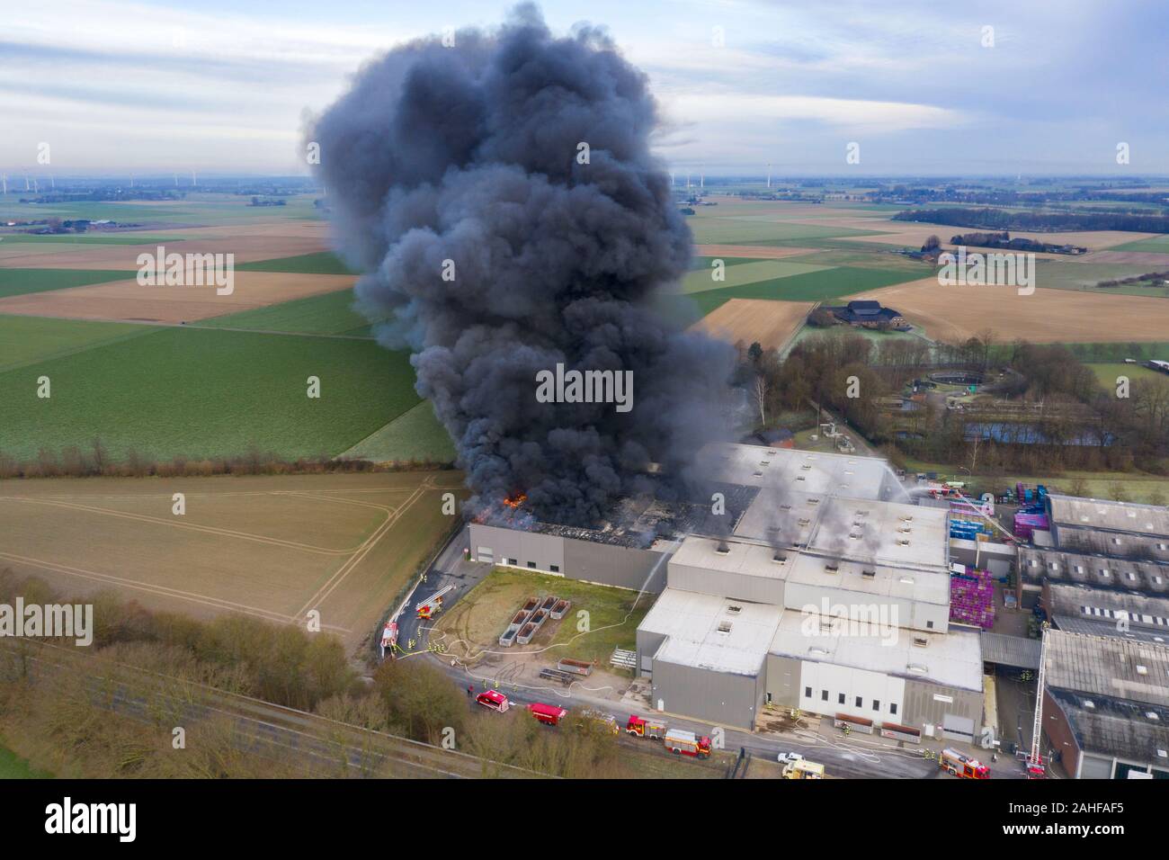Uedem, Deutschland. 29 Dez, 2019. Dichter Rauch kommt aus einer Firma für Auto Teile (geschossen mit einer Drohne). Einige Teile des Gebäudes waren im Feuer zerstört. Wegen der starken Rauchentwicklung, Bewohner wurden aufgefordert, Fenster und Türen geschlossen. Die Polizei es war Brandstiftung. Credit: Arnulf Stoffel/dpa/Alamy leben Nachrichten Stockfoto