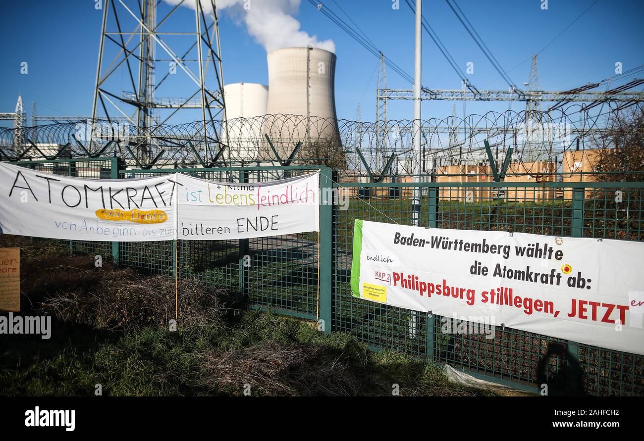 Philippsburg, Deutschland. 29 Dez, 2019. Banner mit der Aufschrift "Atomkraft ist Lebensfeindlich' (l) und "Baden-Württemberg gegen Atomkraft gestimmt. Herunterfahren Philippsburg, jetzt' hängen vor dem Kernkraftwerk Philippsburg während einer Aktion von Anti-AKW-Aktivisten. Zwei Tage vor der endgültigen Abschaltung des Kernkraftwerks Philippsburg 2 Atomreaktor in der Nähe von Karlsruhe, Gegner der Kernenergie feierten das bevorstehende Ende des Kraftwerks. Credit: Christoph Schmidt/dpa/Alamy leben Nachrichten Stockfoto