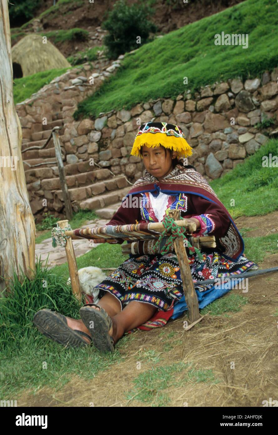 Indigene Frau in bunten Kleidern, Weben an einem Webstuhl Cusco, Peru Stockfoto