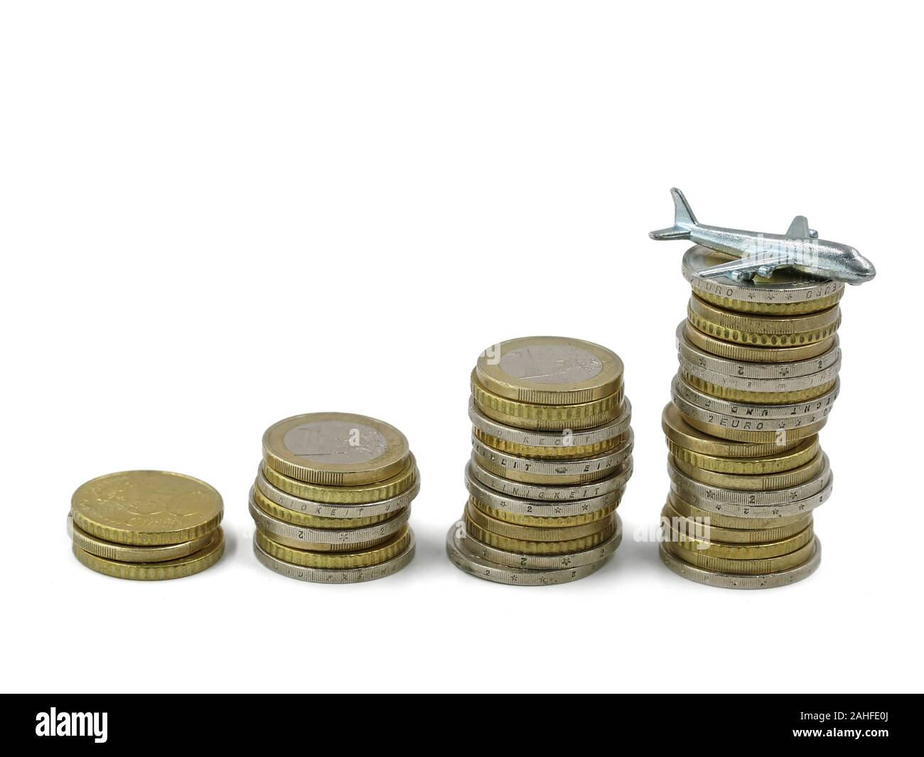 Silber miniatur Flugzeug auf Stapel von Euro-münzen, Konzept von steigenden Kosten für Reisen oder Kerosin Stockfoto