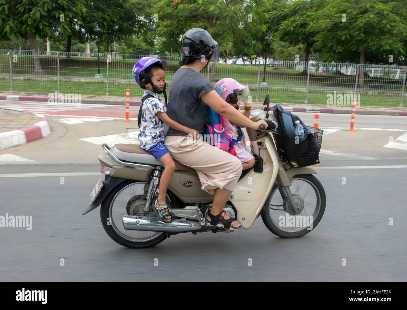 SAMUT PRAKAN, Thailand, 10.Oktober 2019, eine Frau mit kleinen Kindern auf einem Roller in der Stadt. Familie Reise auf dem Motorrad. Stockfoto