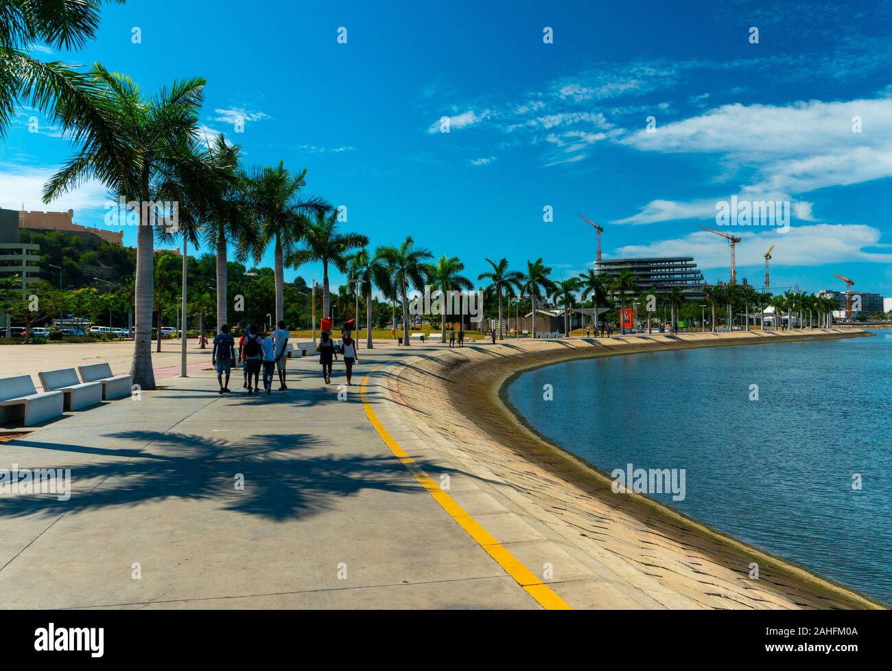 Luanda, angolanischer Zeit - 15. Dezember 2019: Menschen, die an einem sonnigen Tag in der Bucht von Luanda spazieren gehen. Redaktionelle Illustration. Stockfoto