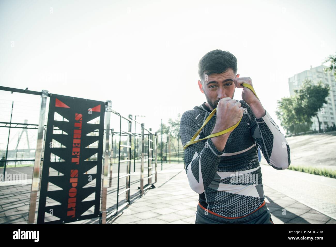Taille bis der Junge Boxer in elastischen Seilen auf seine Hände beim Training Stockfoto