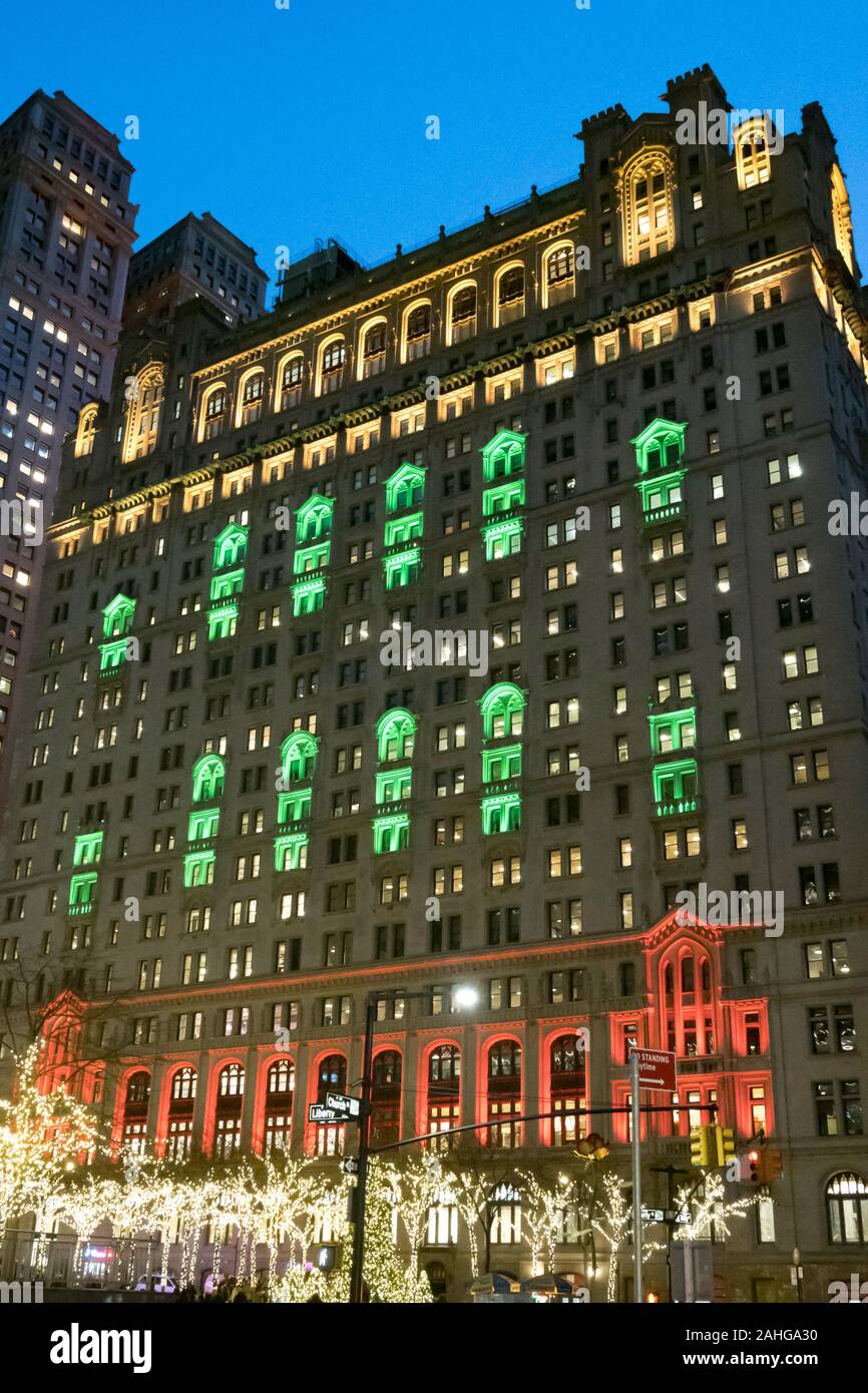 Zuccotti Park mit der Dreifaltigkeit und United States Immo Gebäude im Hintergrund ist hell erleuchtet in der Weihnachtszeit, NYC, USA Stockfoto