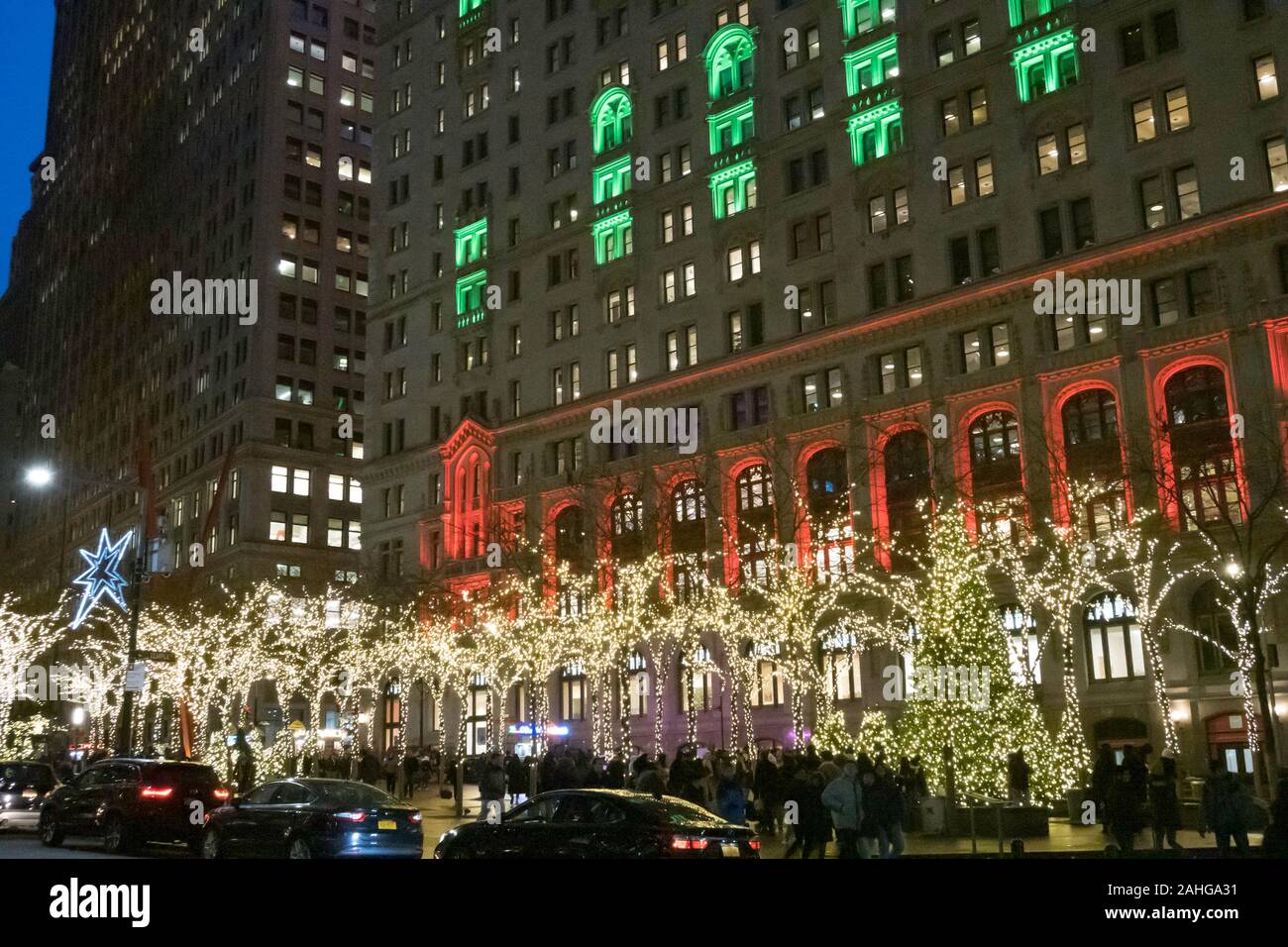 Zuccotti Park mit der Dreifaltigkeit und United States Immo Gebäude im Hintergrund ist hell erleuchtet in der Weihnachtszeit, NYC, USA Stockfoto