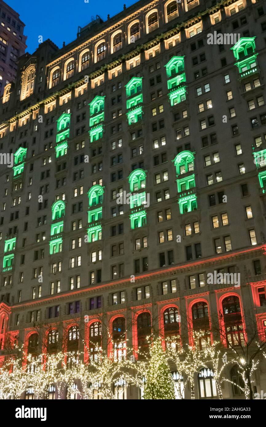 Zuccotti Park mit der Dreifaltigkeit und United States Immo Gebäude im Hintergrund ist hell erleuchtet in der Weihnachtszeit, NYC, USA Stockfoto