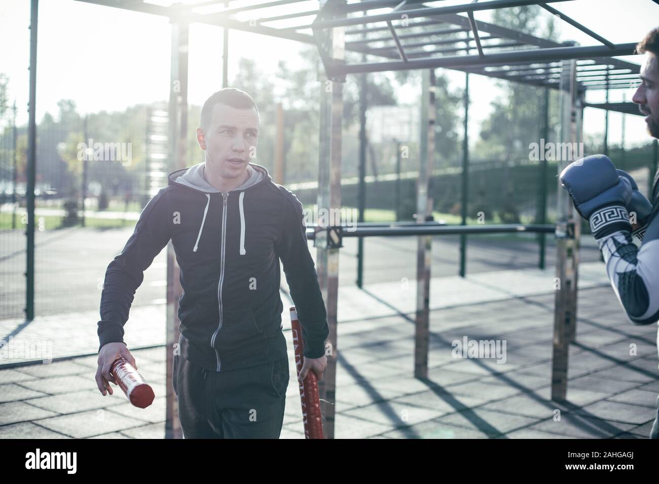 Ruhige trainer Walking mit Boxing Sticks und das Gespräch mit dem Boxer Stockfoto