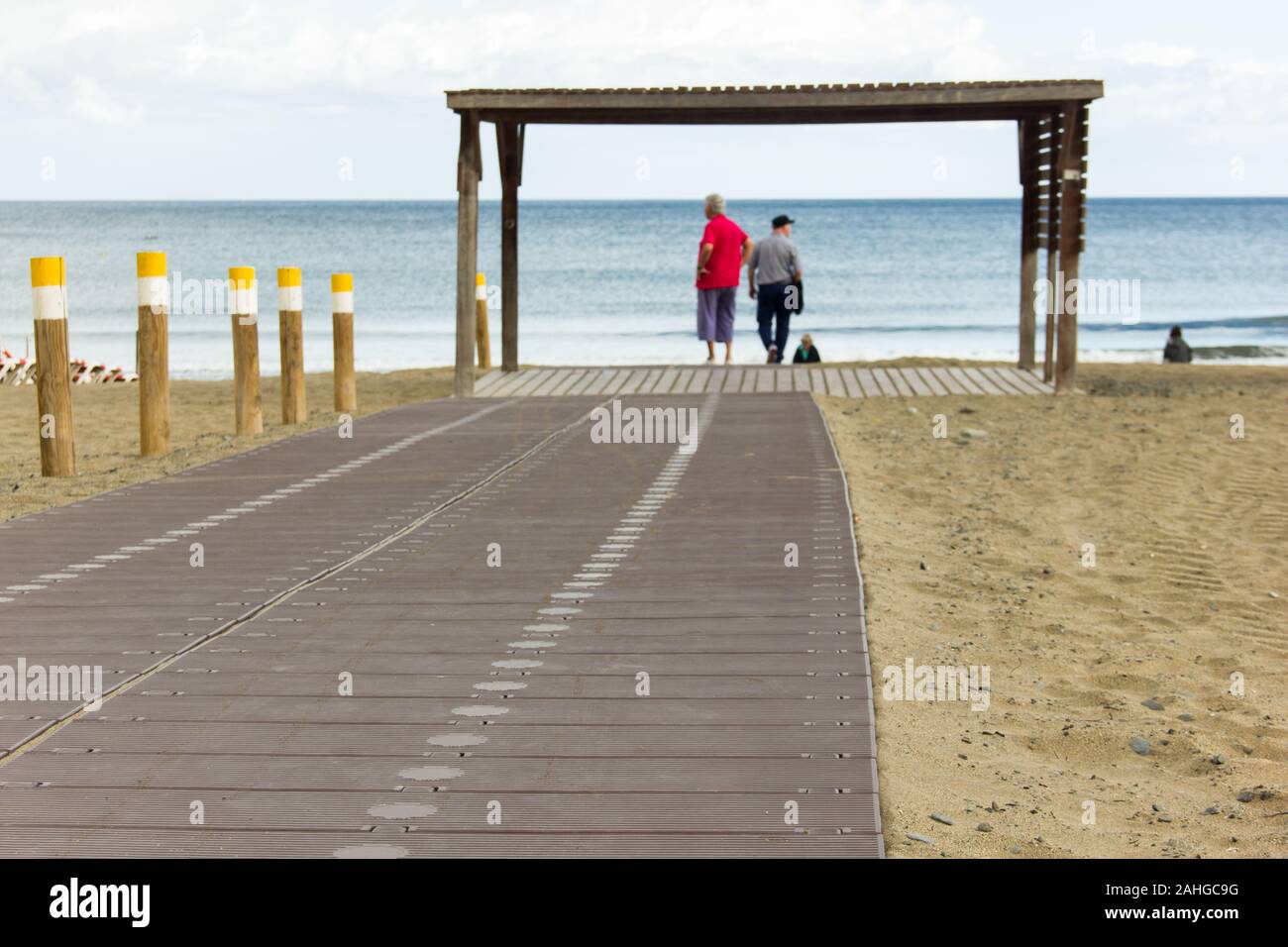 Strandspaziergang mit älteren Touristen verschwommen im Hintergrund in Playa del Ingles, Maspalomas. Reisezielkonzept auf den Kanarischen Inseln, Spanien Stockfoto