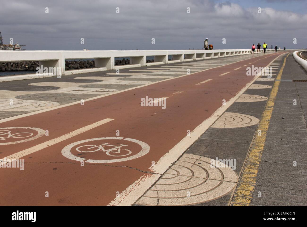 Radwege in roter Richtung neben dem Fußgängerweg an der Küste in Las Palmas, Spanien. Aktivitäten im Freien, gesunde Umwelt, Umweltbelange, Umweltverschmutzung Stockfoto