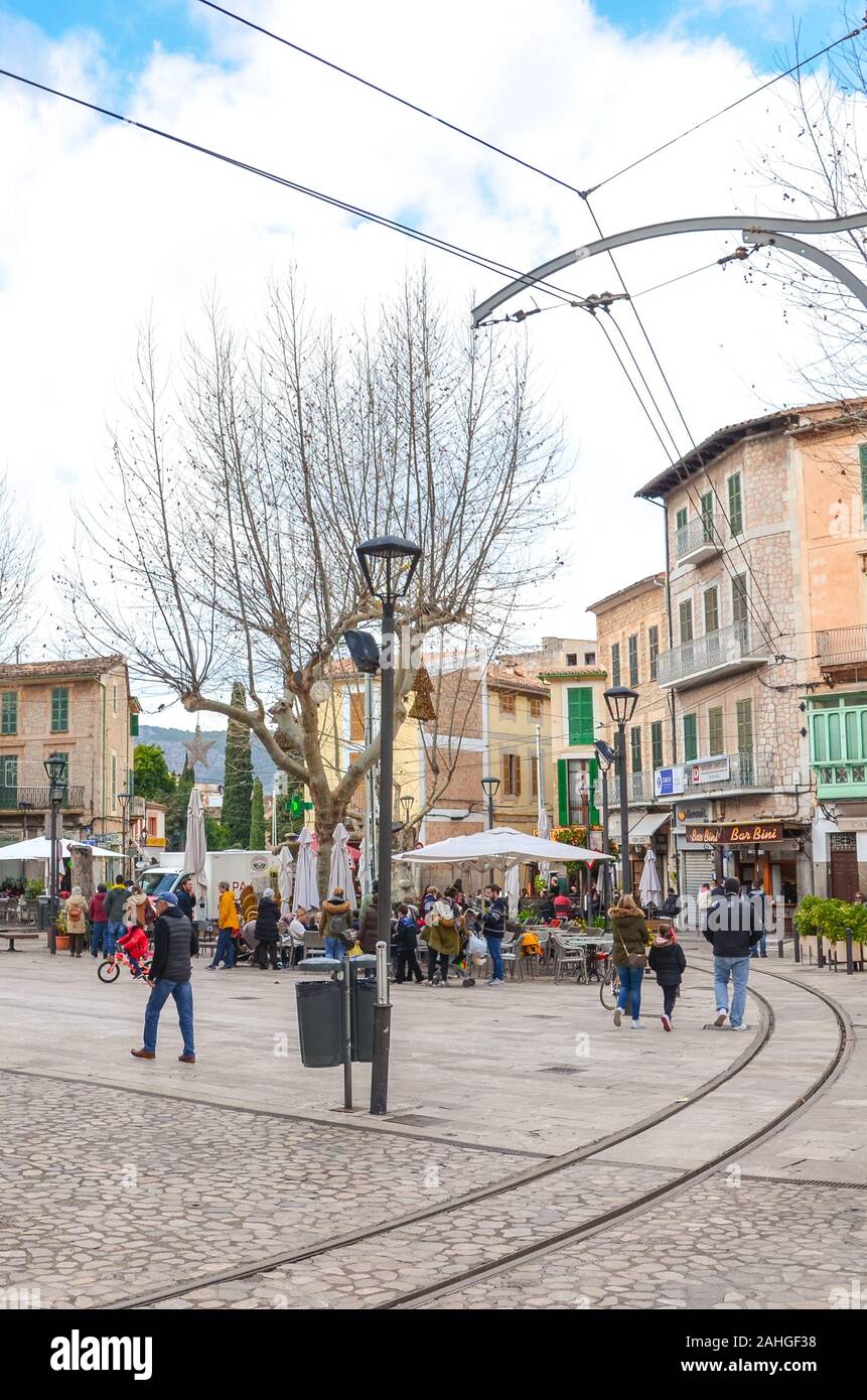 Soller, Mallorca, Spanien - 19 Jan, 2019: Die Verfassung Platz in der Altstadt von der spanischen Stadt. Menschen zu Fuß von Restaurants im Freien im Hintergrund. Vertikale Foto. Stockfoto