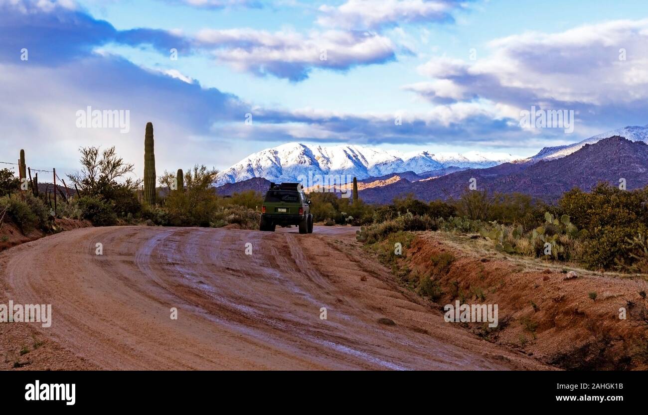 SUV-Fahrzeuge auf einer Forststraße in den vier Peaks Wilderness Recreation Area in Arizona mit Schnee auf den Bergen Stockfoto