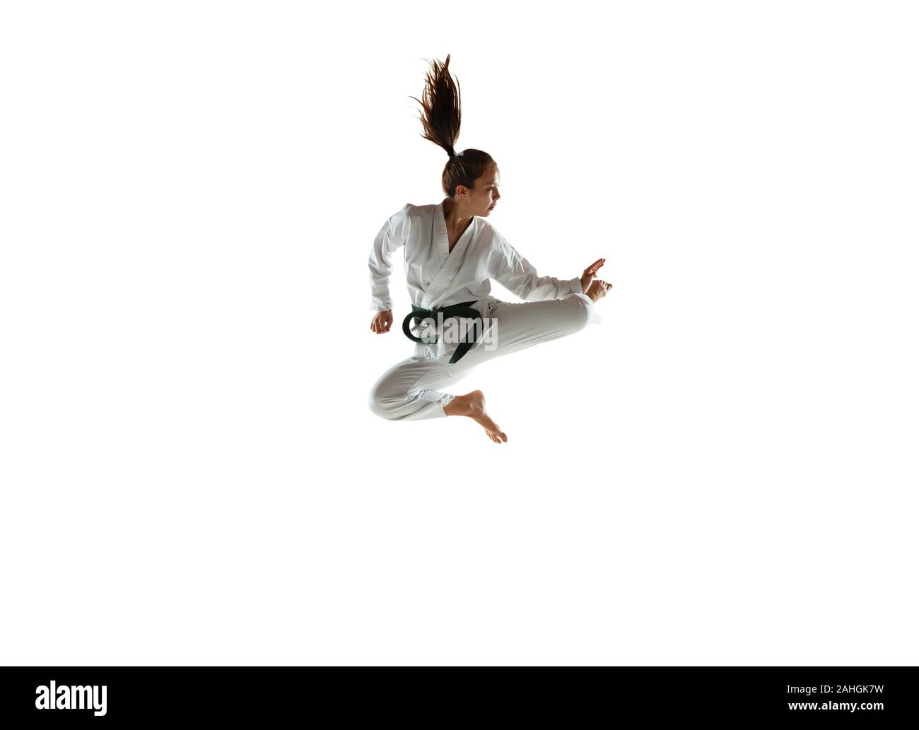 Zuversichtlich junior im Kimono üben Hand-auf-Hand zu bekämpfen, Kampfsportarten Junge weibliche mongolischen Kämpfer mit Green Belt Training auf weißem Studiohintergrund. Konzept der gesunden Lebensstil, Sport, Action. Stockfoto