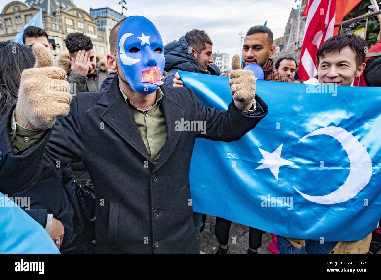 Amsterdam, Niederlande. 18 Mai, 2019. Eine Demonstrantin mit einer Maske nimmt Teil während der Demonstration. Uiguren und Sympathisanten am Dam Square in Amsterdam sammeln ihre Unterstützung mit ethnischen Chinas Uiguren und Protest gegen das, was sie als die Unterdrückung der Uiguren in China von der Regierung dieses Landes zu zeigen. Credit: Niels Wenstedt/SOPA Images/ZUMA Draht/Alamy leben Nachrichten Stockfoto