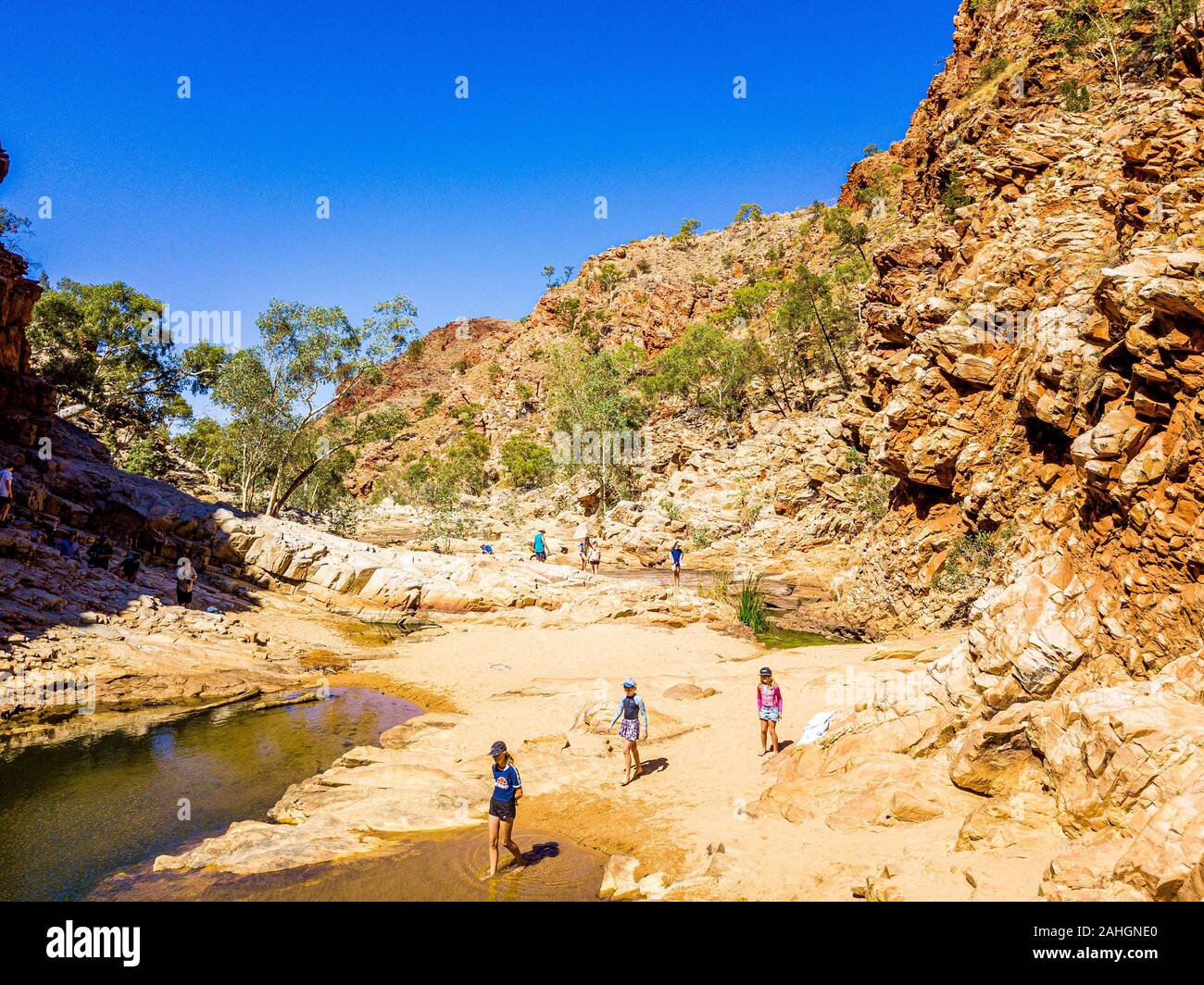 Eine Familie erforscht Redbank Gorge und die eisige Kälte Wasserloch. West MacDonnell Ranges, Northern Territory, Australien. Stockfoto